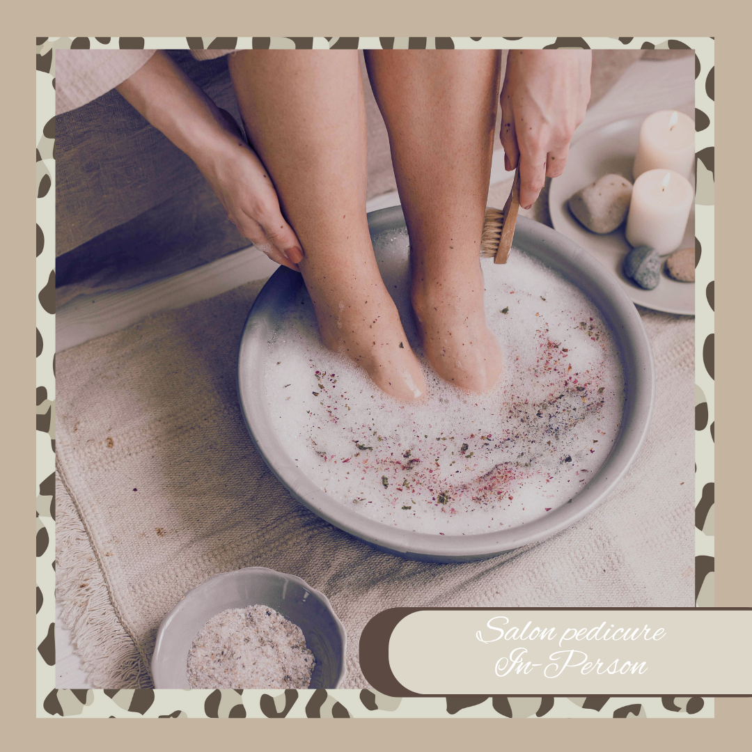 Person getting a foot soak with a bowl of water and scrub, surrounded by candles and stones.